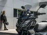 Voge SR1 ADV 4V aparcado frente a un edificio, con su conductora al fondo